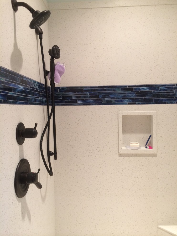 Ejemplo de cuarto de baño principal clásico renovado de tamaño medio con puertas de armario de madera oscura, encimera de cuarzo compacto, bañera exenta, baldosas y/o azulejos azules y suelo de baldosas de porcelana