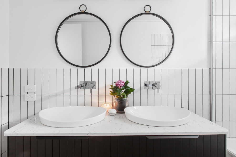 Medium sized eclectic bathroom in Melbourne with black cabinets, a shower/bath combination, white tiles, white walls, a built-in sink, double sinks and a floating vanity unit.