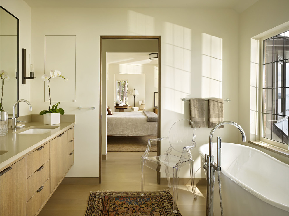 Идея дизайна: главная ванная комната в современном стиле с отдельно стоящей ванной, врезной раковиной, плоскими фасадами, бежевыми стенами, светлым паркетным полом и светлыми деревянными фасадами
