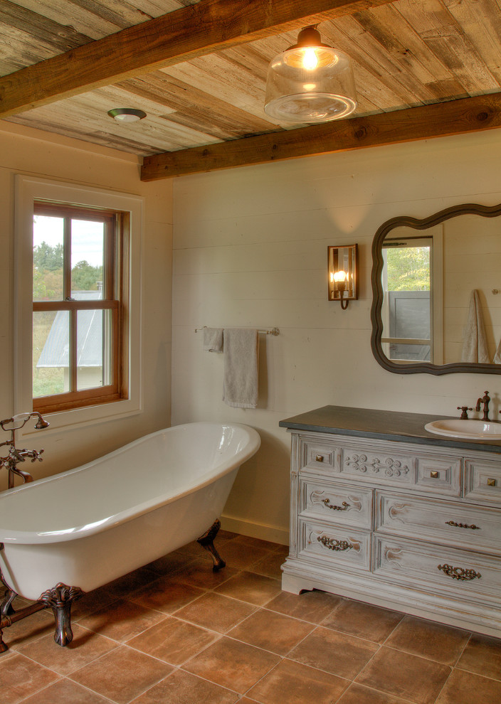 Photo of a medium sized rural ensuite bathroom in Minneapolis with recessed-panel cabinets, grey cabinets, a claw-foot bath, white walls, terracotta flooring, a built-in sink, soapstone worktops and brown floors.