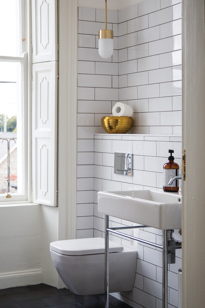 ダブリンにある中くらいなコンテンポラリースタイルのおしゃれなバスルーム (浴槽なし) (オープン型シャワー、壁掛け式トイレ、セラミックタイル、白い壁、コンクリートの床、ペデスタルシンク) の写真