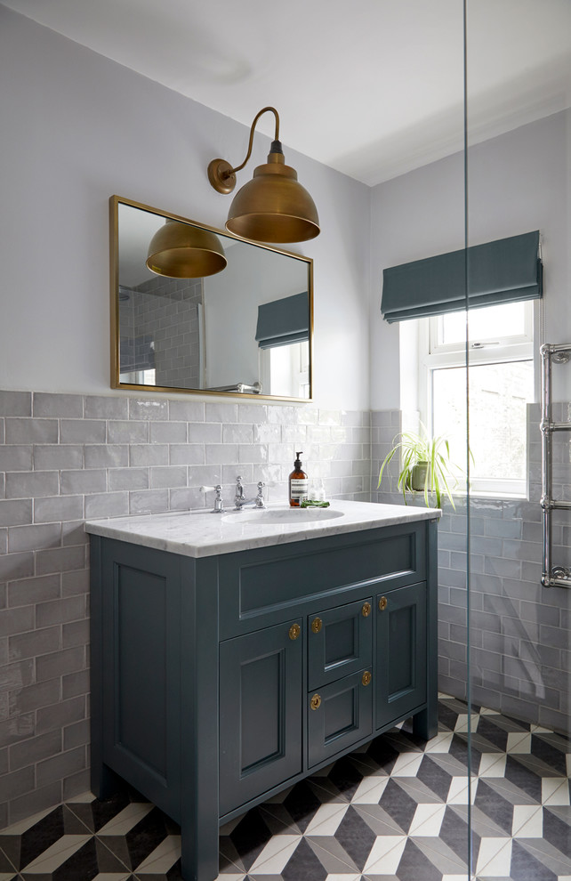 Design ideas for a small modern shower room bathroom in London with freestanding cabinets, blue cabinets, a walk-in shower, a wall mounted toilet, grey tiles, ceramic tiles, white walls, cement flooring, a built-in sink, marble worktops, grey floors, an open shower and white worktops.