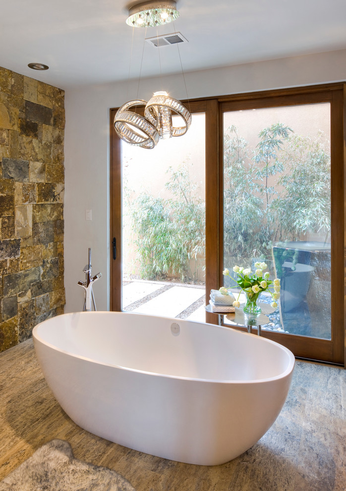 Foto på ett mycket stort funkis badrum, med ett fristående badkar och bruna väggar