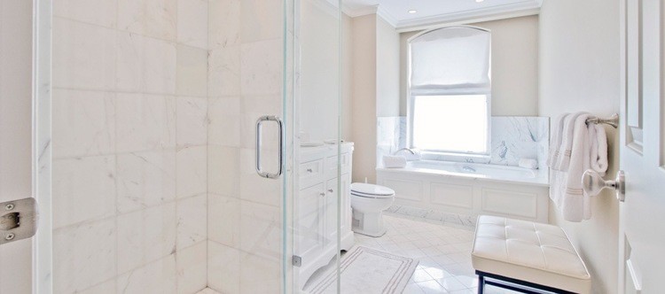 Réalisation d'une douche en alcôve bohème avec un placard en trompe-l'oeil, des portes de placard blanches, une baignoire encastrée, un carrelage blanc, un carrelage de pierre, un mur beige et un sol en marbre.