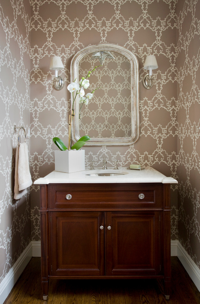 Ispirazione per una stanza da bagno tradizionale con lavabo sottopiano, ante con bugna sagomata, ante in legno bruno e pareti multicolore