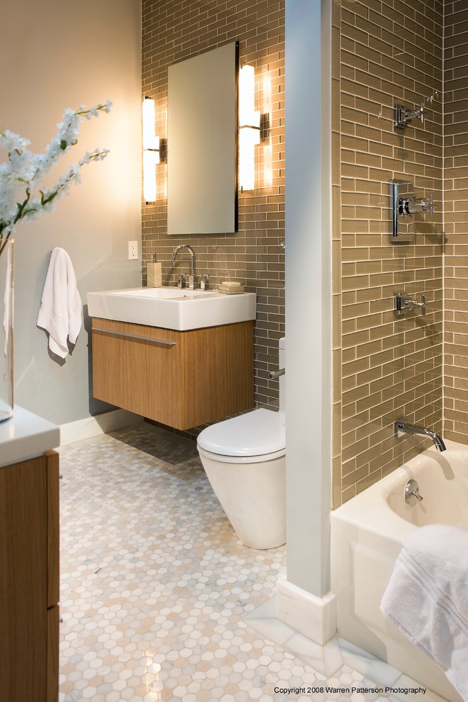 Inspiration for a mid-sized contemporary master brown tile and glass tile marble floor bathroom remodel in Boston with flat-panel cabinets, light wood cabinets, a one-piece toilet, brown walls, an integrated sink, quartz countertops and white countertops