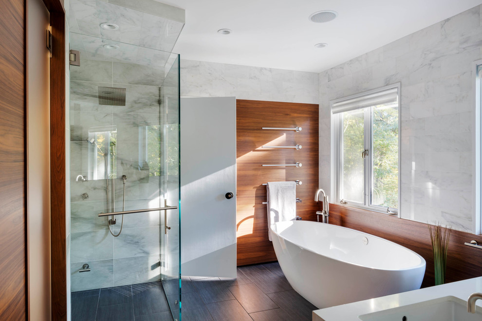 На фото: главная ванная комната в современном стиле с врезной раковиной, отдельно стоящей ванной, душем без бортиков и белой плиткой
