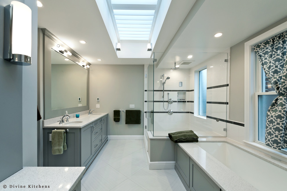 Aménagement d'une grande salle de bain principale classique avec un lavabo encastré, un placard avec porte à panneau surélevé, des portes de placard grises, une baignoire d'angle, une douche d'angle, un carrelage beige et un mur gris.
