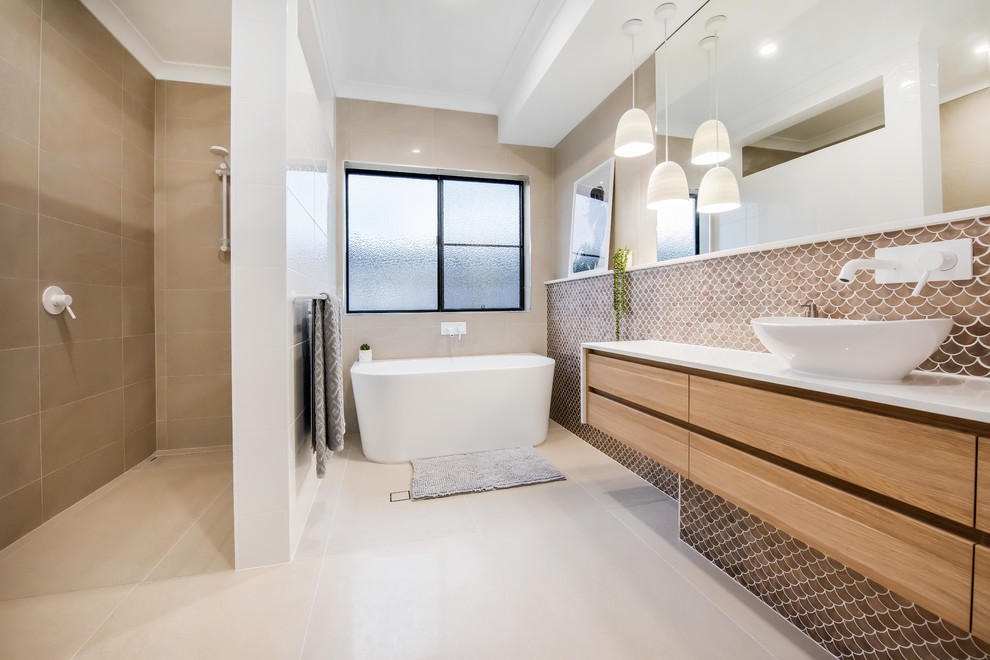 Пример оригинального дизайна: большая главная ванная комната в современном стиле с плоскими фасадами, отдельно стоящей ванной, коричневой плиткой, настольной раковиной, открытым душем, белой столешницей, светлыми деревянными фасадами, открытым душем, керамической плиткой, белыми стенами, полом из керамической плитки, столешницей из гранита, белым полом, нишей, тумбой под одну раковину, подвесной тумбой и инсталляцией
