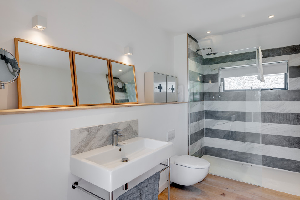 Idée de décoration pour une grande salle de bain design avec une douche ouverte, WC suspendus, un carrelage noir et blanc, un mur blanc, parquet clair, un plan vasque, un sol beige et aucune cabine.