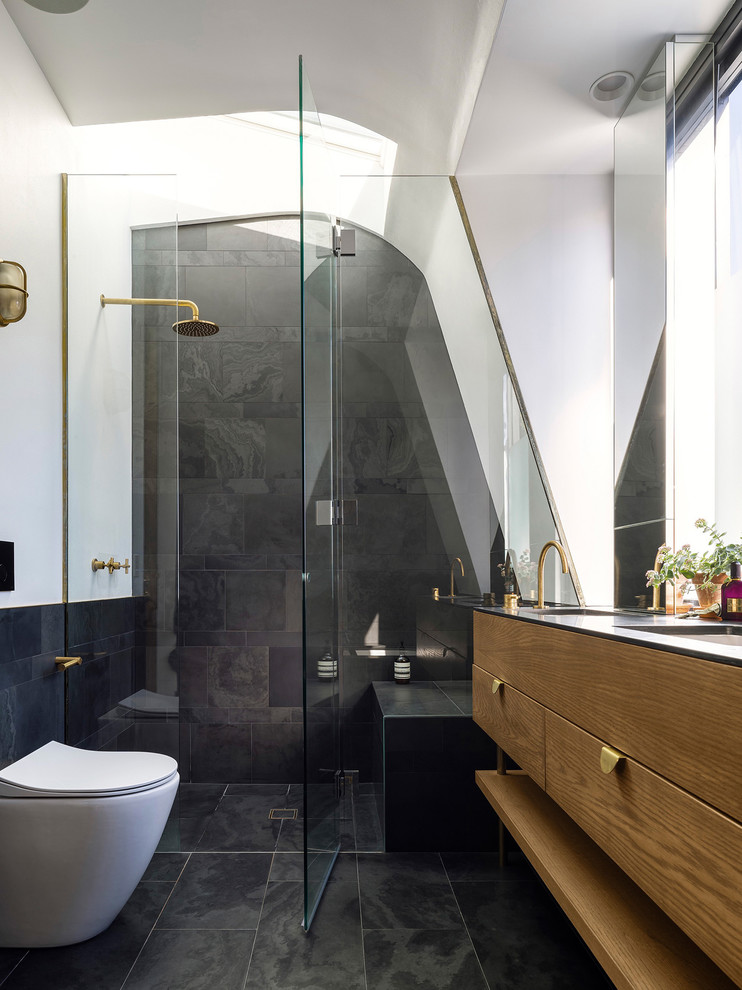 Idee per una stanza da bagno minimal con ante lisce, ante in legno bruno, doccia alcova, pareti bianche, lavabo integrato, pavimento nero e porta doccia a battente