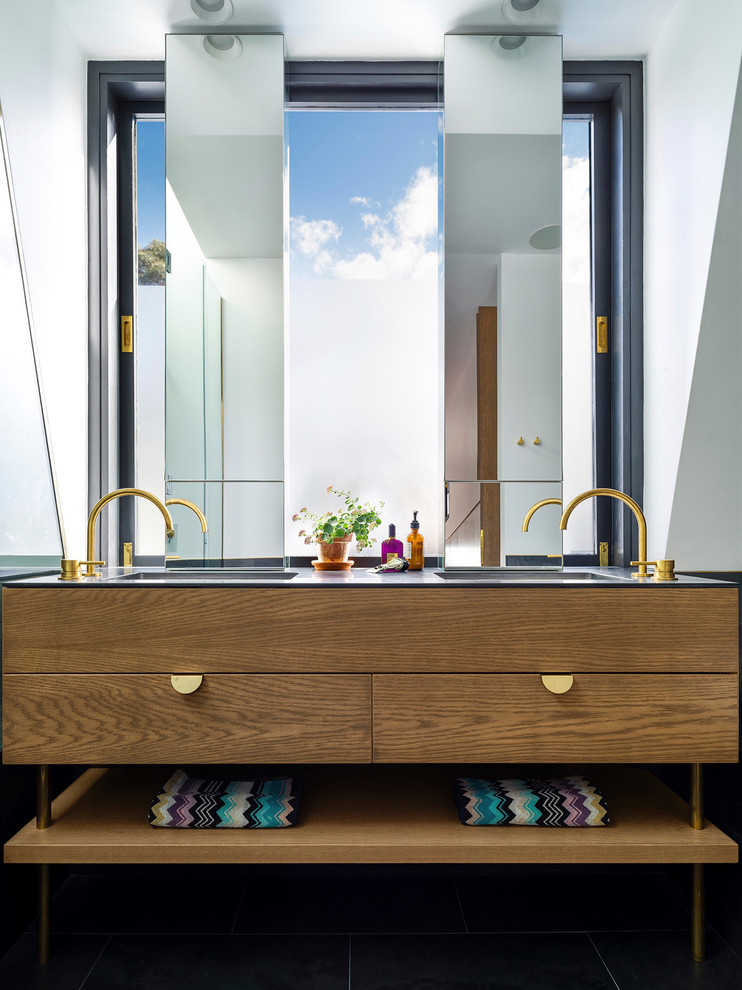 Foto di una stanza da bagno minimal con ante lisce, ante in legno bruno, pareti bianche, lavabo integrato e pavimento nero
