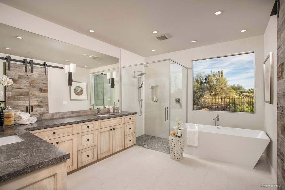 Mid-sized trendy master white tile and porcelain tile porcelain tile freestanding bathtub photo in Phoenix with light wood cabinets, white walls, an undermount sink and marble countertops