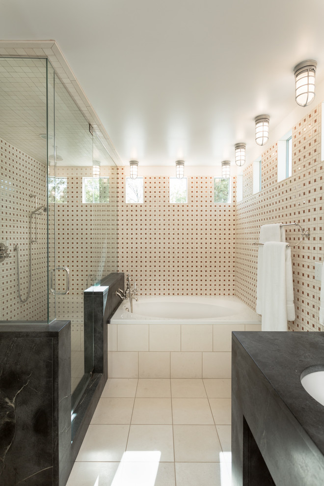 Cette photo montre une salle de bain principale tendance avec un lavabo encastré, une baignoire posée, une douche double, un carrelage beige et un mur multicolore.