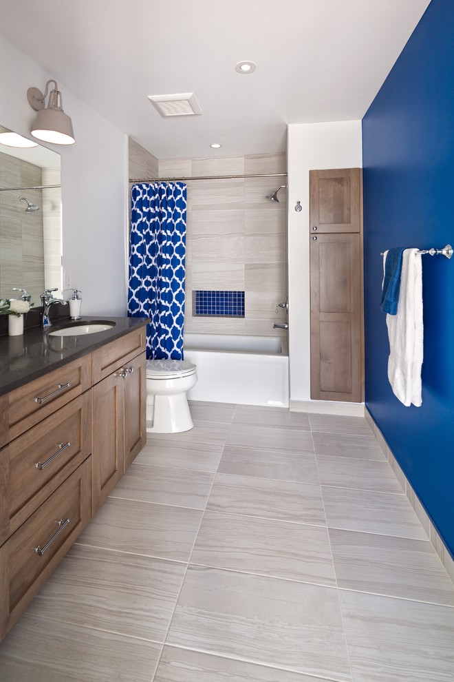 Idée de décoration pour une salle de bain tradition en bois brun de taille moyenne avec un placard à porte shaker, une baignoire en alcôve, un combiné douche/baignoire, WC séparés, un carrelage bleu, des carreaux de céramique, un mur bleu, un sol en carrelage de porcelaine, un lavabo encastré, un plan de toilette en marbre, un sol beige et une cabine de douche avec un rideau.