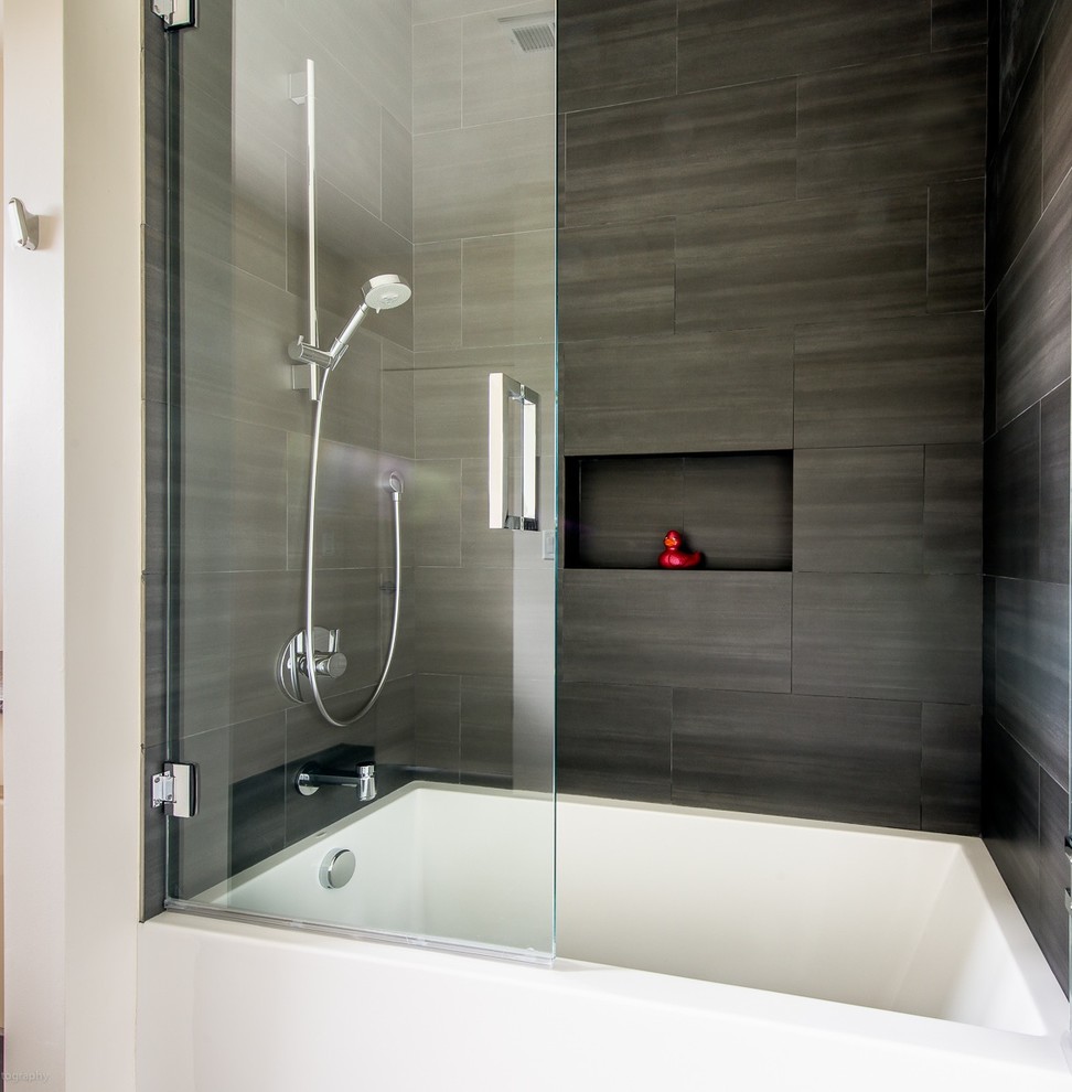Idée de décoration pour une salle de bain design de taille moyenne avec une baignoire en alcôve, un combiné douche/baignoire, un carrelage gris et des carreaux de porcelaine.