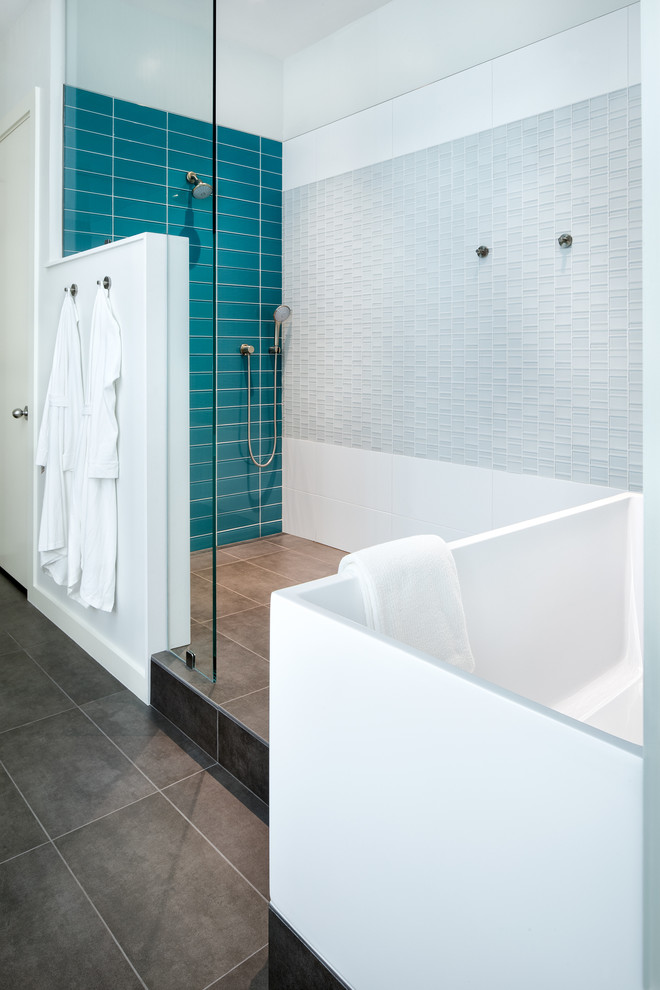 オースティンにある高級な中くらいなコンテンポラリースタイルのおしゃれなマスターバスルーム (置き型浴槽、オープン型シャワー、青いタイル、ガラスタイル、青い壁、セラミックタイルの床) の写真