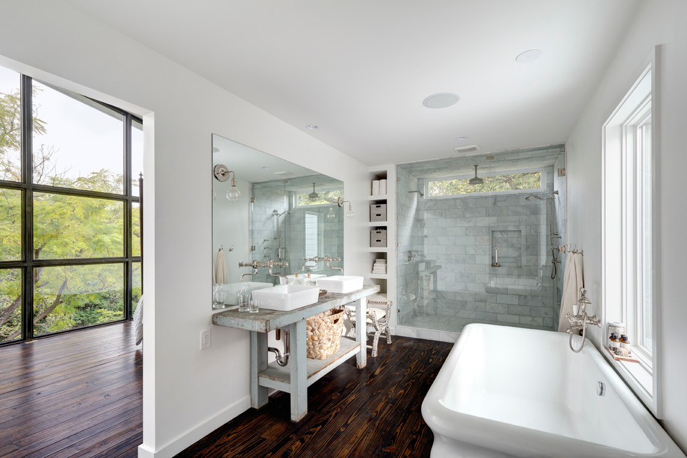 Idéer för att renovera ett stort funkis en-suite badrum, med ett fristående handfat, öppna hyllor, blå skåp, ett fristående badkar, en öppen dusch, grå kakel, vita väggar och mörkt trägolv