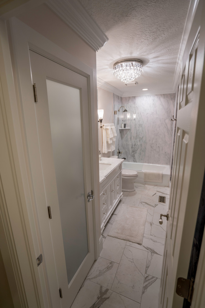 This is an example of a small traditional shower room bathroom in Salt Lake City with recessed-panel cabinets, white cabinets, an alcove bath, a shower/bath combination, a two-piece toilet, black and white tiles, stone tiles, beige walls, porcelain flooring, a submerged sink and granite worktops.