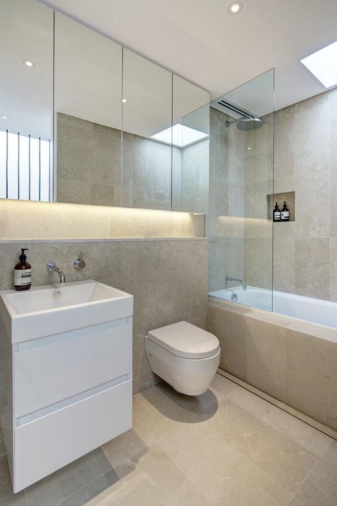 Пример оригинального дизайна: ванная комната в современном стиле с бежевой плиткой, каменной плиткой, бежевыми стенами, полом из известняка и накладной ванной