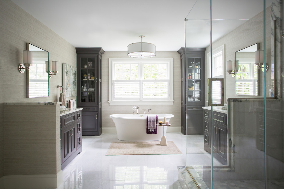 На фото: большая главная ванная комната в классическом стиле с фасадами с утопленной филенкой, отдельно стоящей ванной, угловым душем, врезной раковиной и белым полом