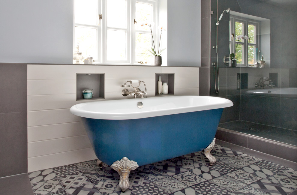 Design ideas for a large modern ensuite bathroom in Oxfordshire with an integrated sink, flat-panel cabinets, white cabinets, a claw-foot bath, a walk-in shower, a wall mounted toilet, grey tiles, porcelain tiles, blue walls and porcelain flooring.