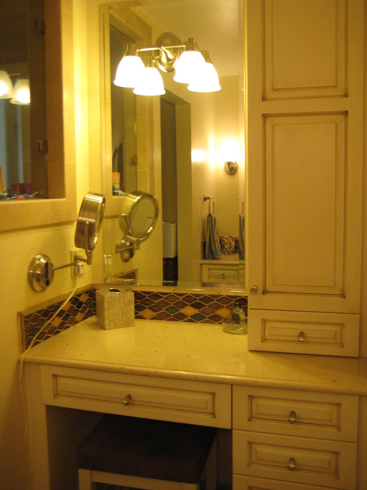 Пример оригинального дизайна: маленькая главная ванная комната в стиле неоклассика (современная классика) с врезной раковиной, фасадами с выступающей филенкой, белыми фасадами, столешницей из искусственного камня, ванной в нише, душем над ванной, раздельным унитазом, разноцветной плиткой, плиткой из листового стекла, желтыми стенами и полом из известняка для на участке и в саду