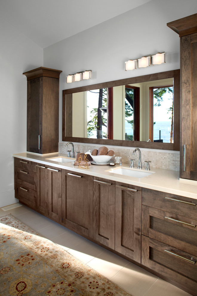 Foto di una stanza da bagno minimal con lavabo sottopiano, ante in legno bruno e piastrelle beige