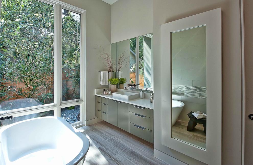 Imagen de cuarto de baño rectangular actual con bañera exenta y lavabo sobreencimera