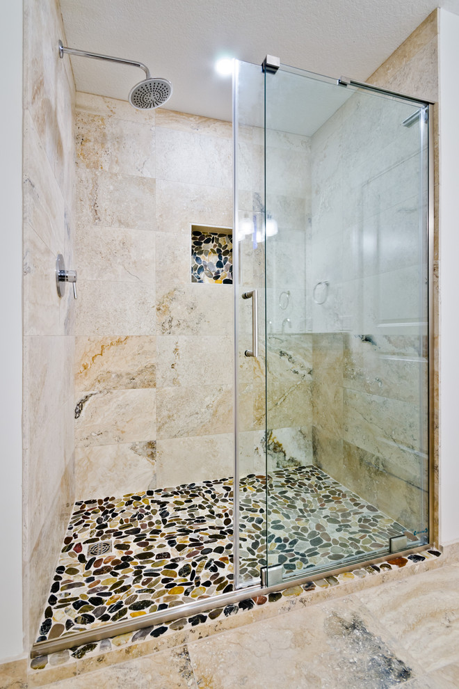 Photo of a small traditional ensuite bathroom in Calgary with shaker cabinets, medium wood cabinets, a one-piece toilet, multi-coloured tiles, travertine tiles, white walls, travertine flooring, a submerged sink, granite worktops, multi-coloured floors and black worktops.