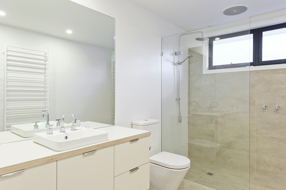 Example of a large trendy kids' beige tile and porcelain tile ceramic tile double shower design in Melbourne with flat-panel cabinets, white cabinets, a one-piece toilet, white walls, an integrated sink and laminate countertops