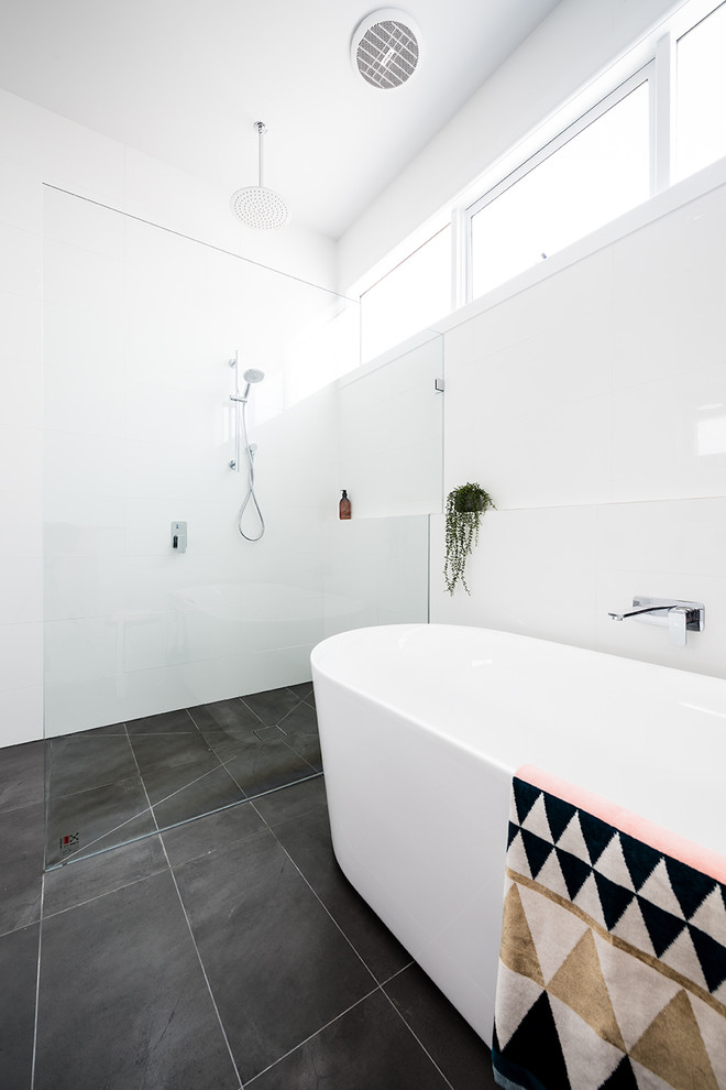 Mittelgroßes Modernes Duschbad mit freistehender Badewanne, bodengleicher Dusche, weißen Fliesen, Porzellanfliesen, weißer Wandfarbe, Keramikboden, grauem Boden und offener Dusche