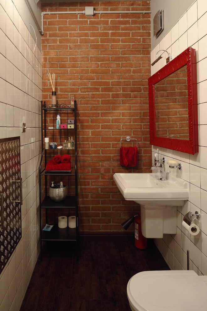 Immagine di una stanza da bagno industriale con lavabo sospeso, piastrelle bianche e parquet scuro