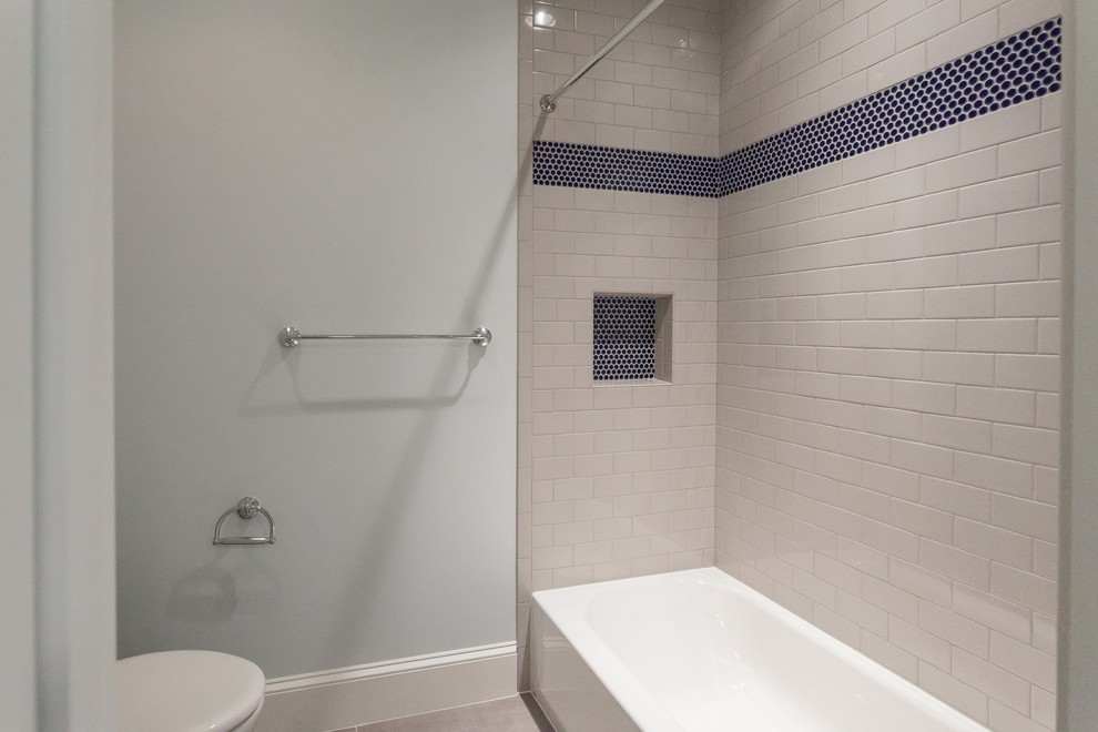 Cette image montre une salle de bain traditionnelle pour enfant avec un placard avec porte à panneau encastré, des portes de placard bleues, une baignoire en alcôve, un combiné douche/baignoire, un carrelage multicolore, un carrelage métro, un mur bleu, un lavabo encastré, un sol beige, une cabine de douche avec un rideau et un plan de toilette blanc.