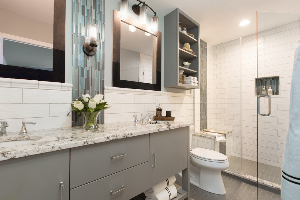 Double shower - mid-sized modern kids' gray tile and ceramic tile mosaic tile floor and gray floor double shower idea in St Louis with flat-panel cabinets, gray cabinets, a two-piece toilet, blue walls, granite countertops, a hinged shower door, an undermount sink and beige countertops