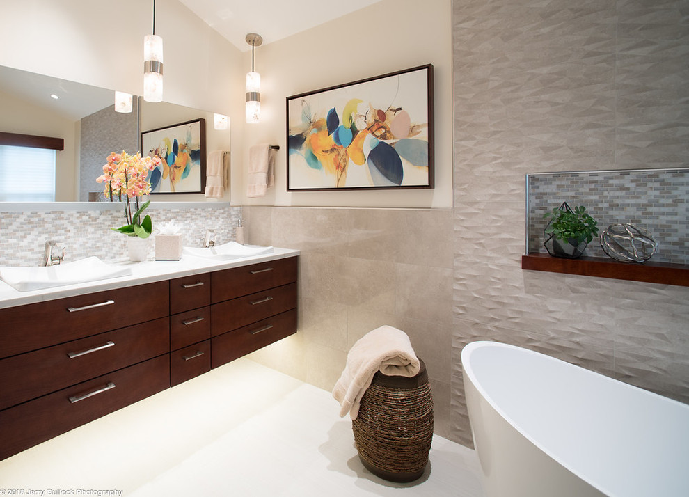 This is an example of a large modern ensuite bathroom in DC Metro with flat-panel cabinets, brown cabinets, a freestanding bath, a built-in shower, a one-piece toilet, beige tiles, porcelain tiles, beige walls, porcelain flooring, a built-in sink, engineered stone worktops, beige floors, an open shower and white worktops.