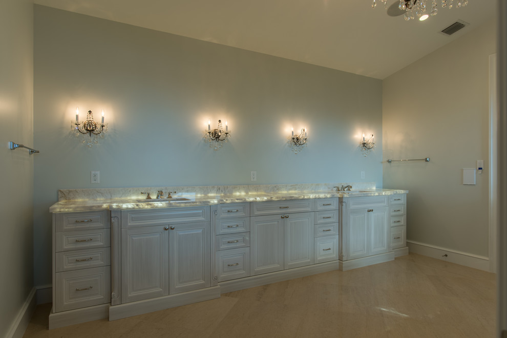 Стильный дизайн: главная ванная комната среднего размера в стиле неоклассика (современная классика) с фасадами с выступающей филенкой, белыми фасадами, столешницей из оникса, полом из керамогранита, синими стенами и врезной раковиной - последний тренд