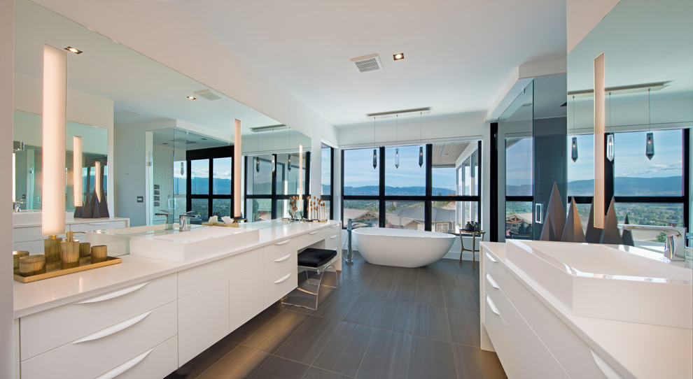 Свежая идея для дизайна: огромная главная ванная комната в стиле модернизм с белыми фасадами, отдельно стоящей ванной, душем в нише, инсталляцией, белой плиткой, белыми стенами, настольной раковиной, коричневым полом и душем с распашными дверями - отличное фото интерьера