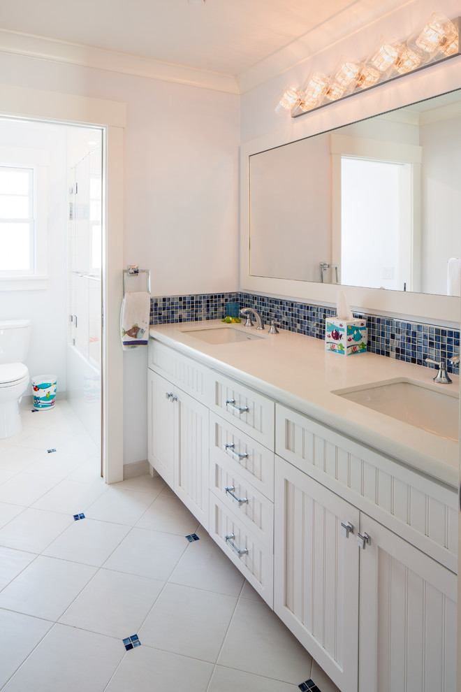 Exempel på ett mellanstort klassiskt badrum med dusch, med ett piedestal handfat, luckor med profilerade fronter, vita skåp, en dusch/badkar-kombination, en toalettstol med separat cisternkåpa, flerfärgad kakel, blå väggar och klinkergolv i porslin