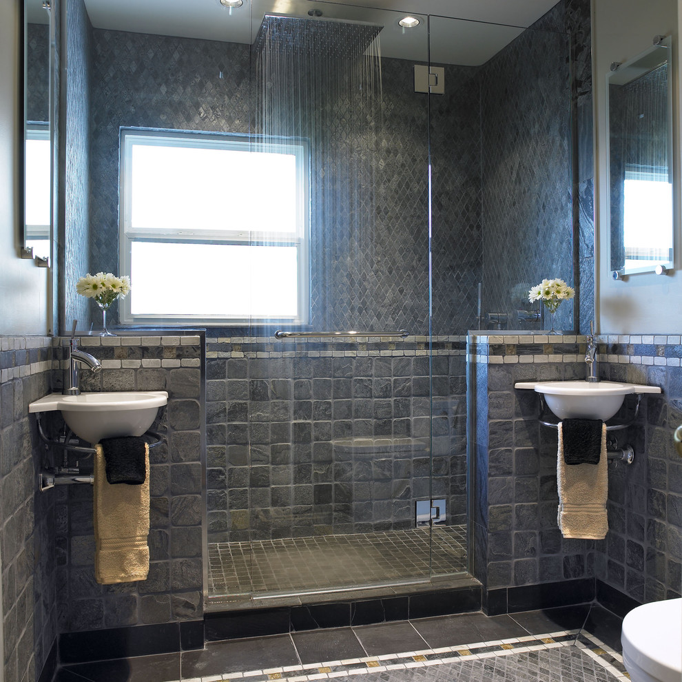Modelo de cuarto de baño actual con baldosas y/o azulejos de piedra, lavabo suspendido y ventanas