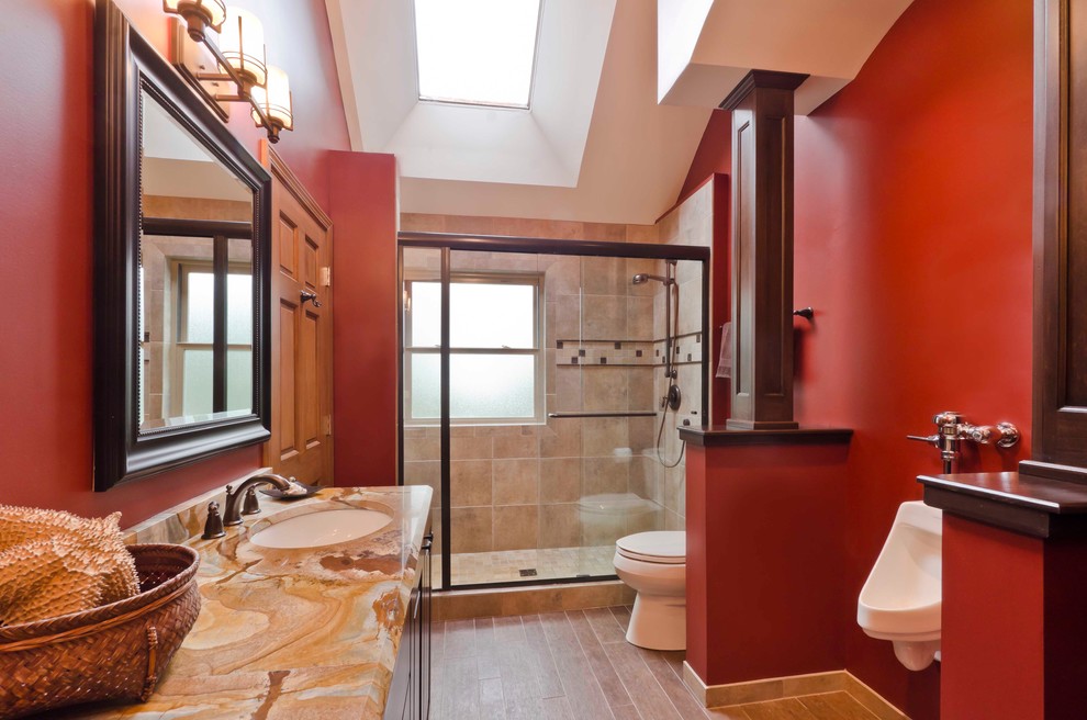 Alcove shower - mid-sized traditional kids' beige tile and porcelain tile porcelain tile alcove shower idea in Chicago with an undermount sink, raised-panel cabinets, dark wood cabinets, marble countertops, an urinal and red walls