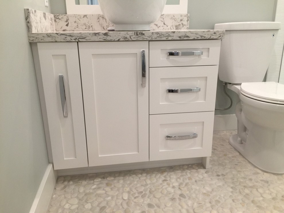 Medium sized contemporary bathroom in Vancouver with shaker cabinets, white cabinets, an alcove shower, a two-piece toilet, white tiles, stone tiles, pebble tile flooring, a vessel sink and engineered stone worktops.