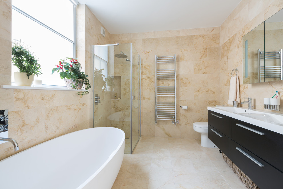 Large elegant kids' beige tile beige floor bathroom photo in London with flat-panel cabinets, dark wood cabinets, a one-piece toilet, a wall-mount sink, beige walls and a hinged shower door