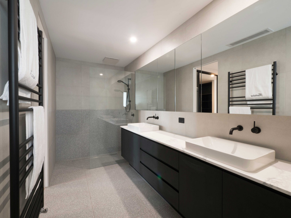 Immagine di una grande stanza da bagno padronale minimalista con ante nere, doccia aperta, piastrelle grigie, piastrelle di cemento, pavimento in cementine, lavabo a bacinella, top in marmo, pavimento grigio, doccia aperta, top grigio e due lavabi