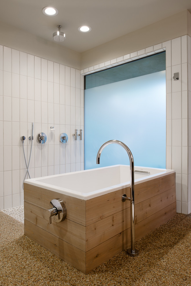 Retro bathroom in Austin with pebble tile flooring, a freestanding bath, white tiles, beige walls and a built-in shower.