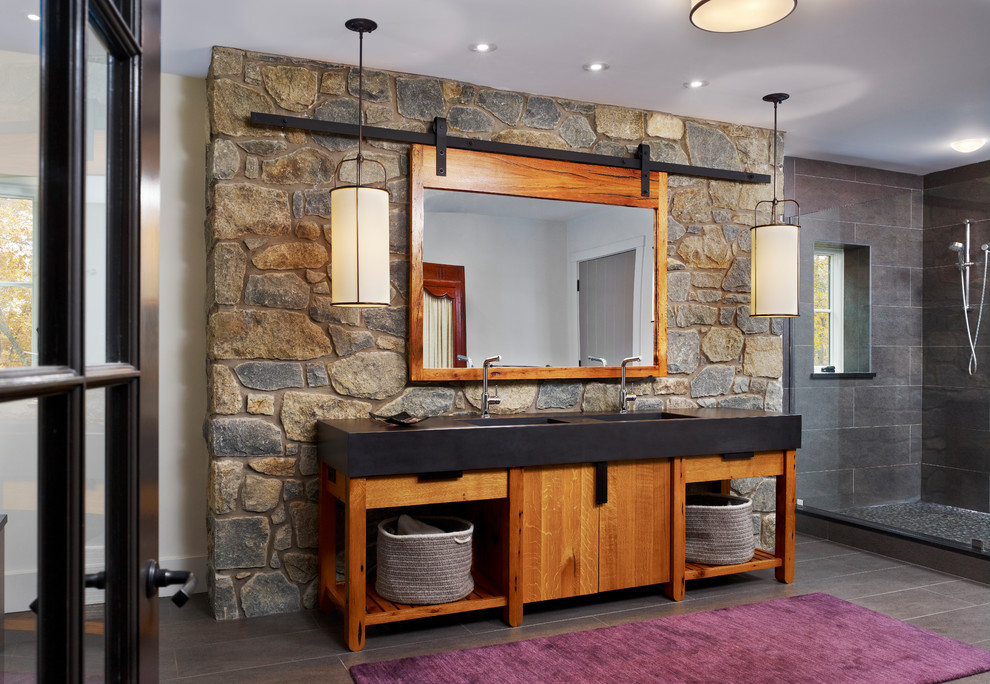 Imagen de cuarto de baño campestre con puertas de armario de madera oscura, armarios con paneles lisos y piedra