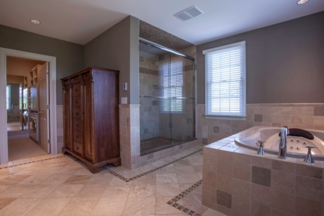 Mid-sized transitional master multicolored tile and stone tile drop-in bathtub photo in Boston with an integrated sink, recessed-panel cabinets, brown cabinets, tile countertops, a one-piece toilet and beige walls