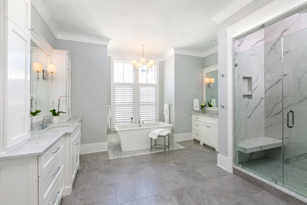 Cette photo montre une douche en alcôve chic avec un placard à porte shaker, des portes de placard blanches, un carrelage gris, un mur gris, un lavabo encastré, un sol gris, une cabine de douche à porte battante et un plan de toilette gris.