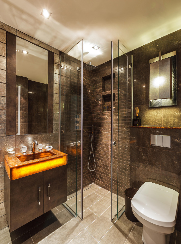 Modernes Badezimmer mit integriertem Waschbecken, flächenbündigen Schrankfronten, Eckdusche, Toilette mit Aufsatzspülkasten und braunen Fliesen in London