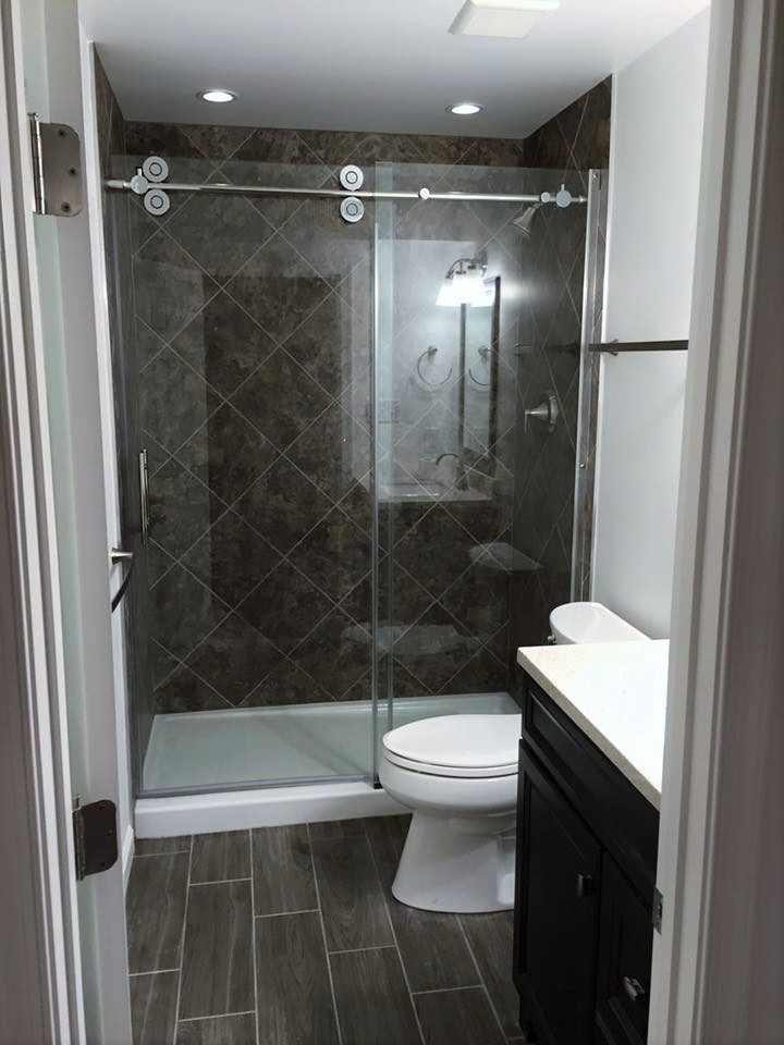 Inspiration for a small classic bathroom in DC Metro with recessed-panel cabinets, black cabinets, an alcove shower, a two-piece toilet, grey tiles, white walls and ceramic flooring.